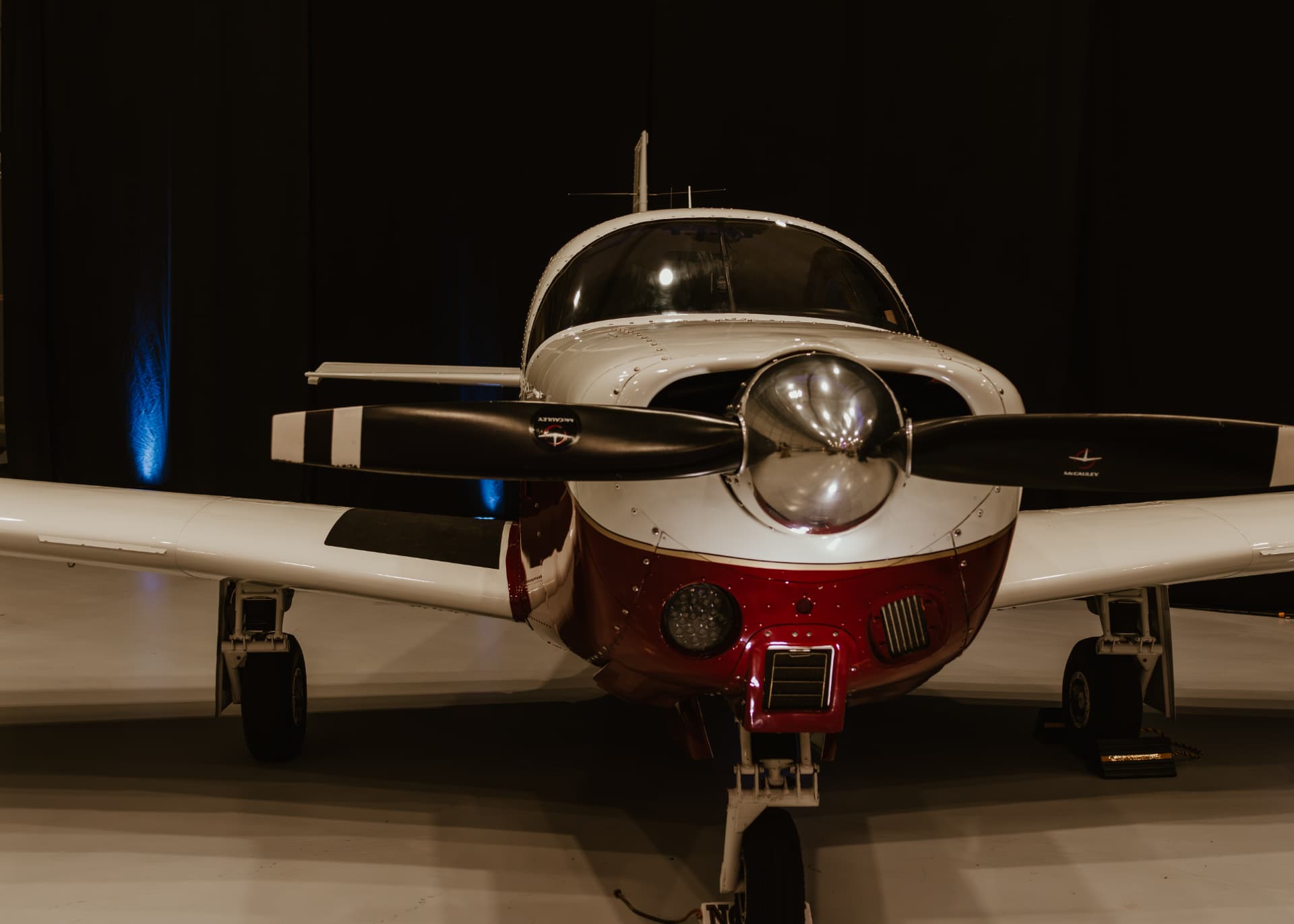 Vintage propeller aircraft uplit in blue at a hangar reception