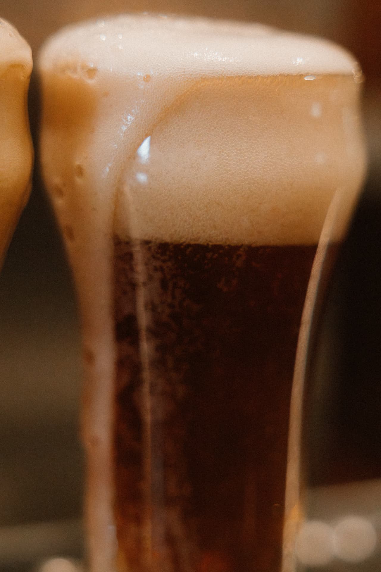 Close-up of a dark amber Redwood ale with a thick foam head