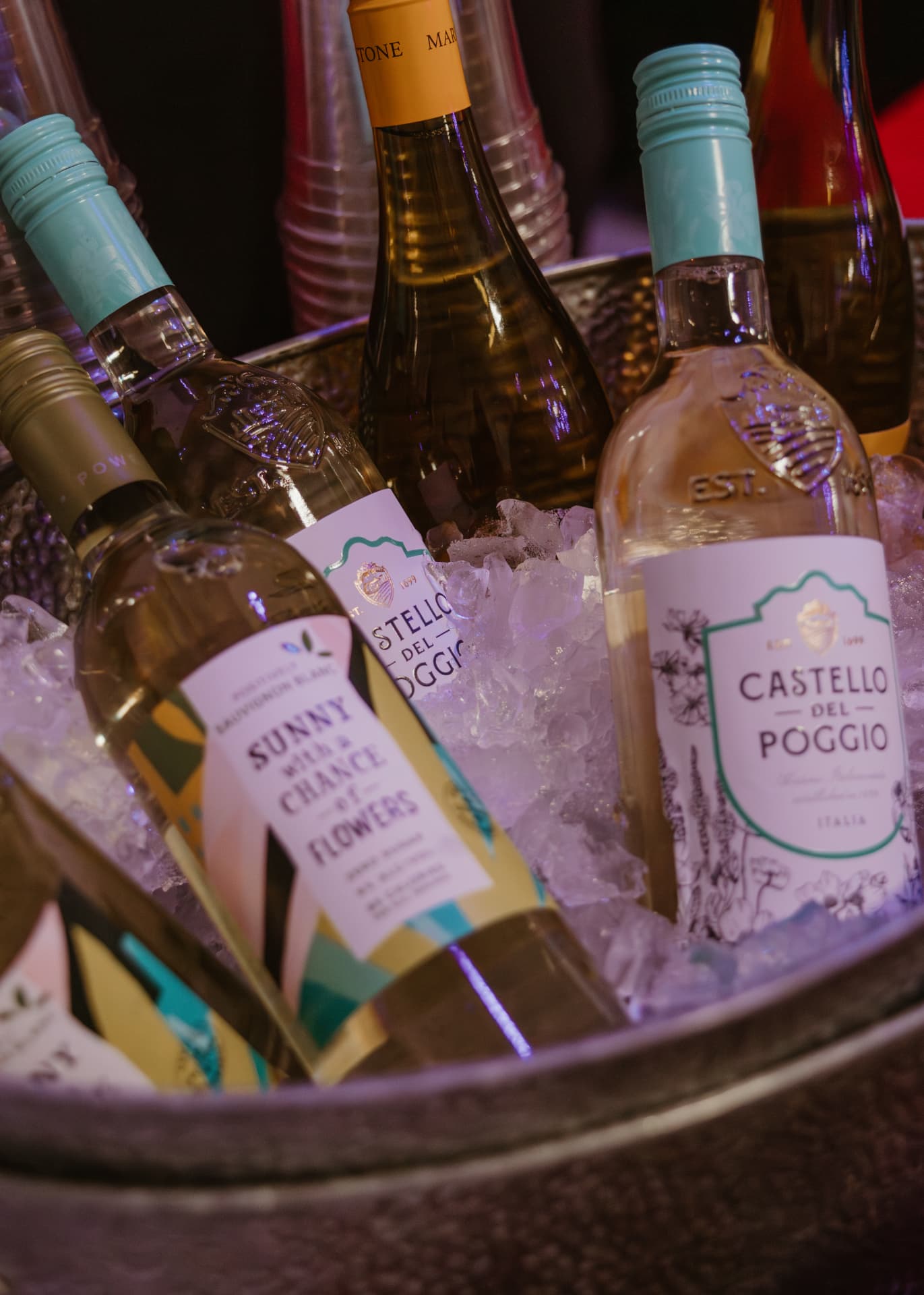 Chilled white and rosé wine bottles in an ice bucket at the bar