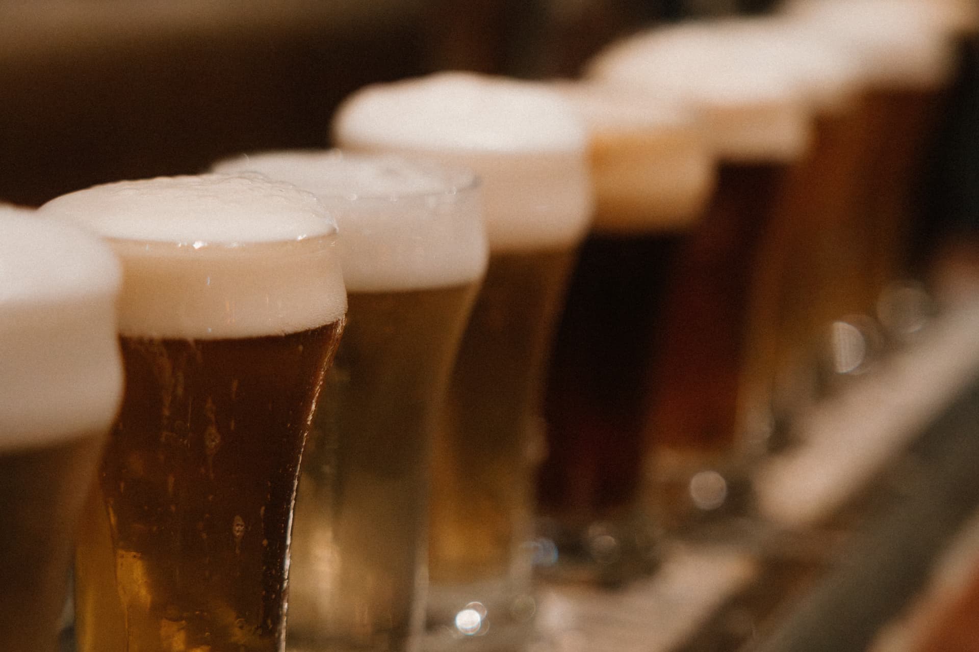 A flight of Redwood beers in soft light along the bar