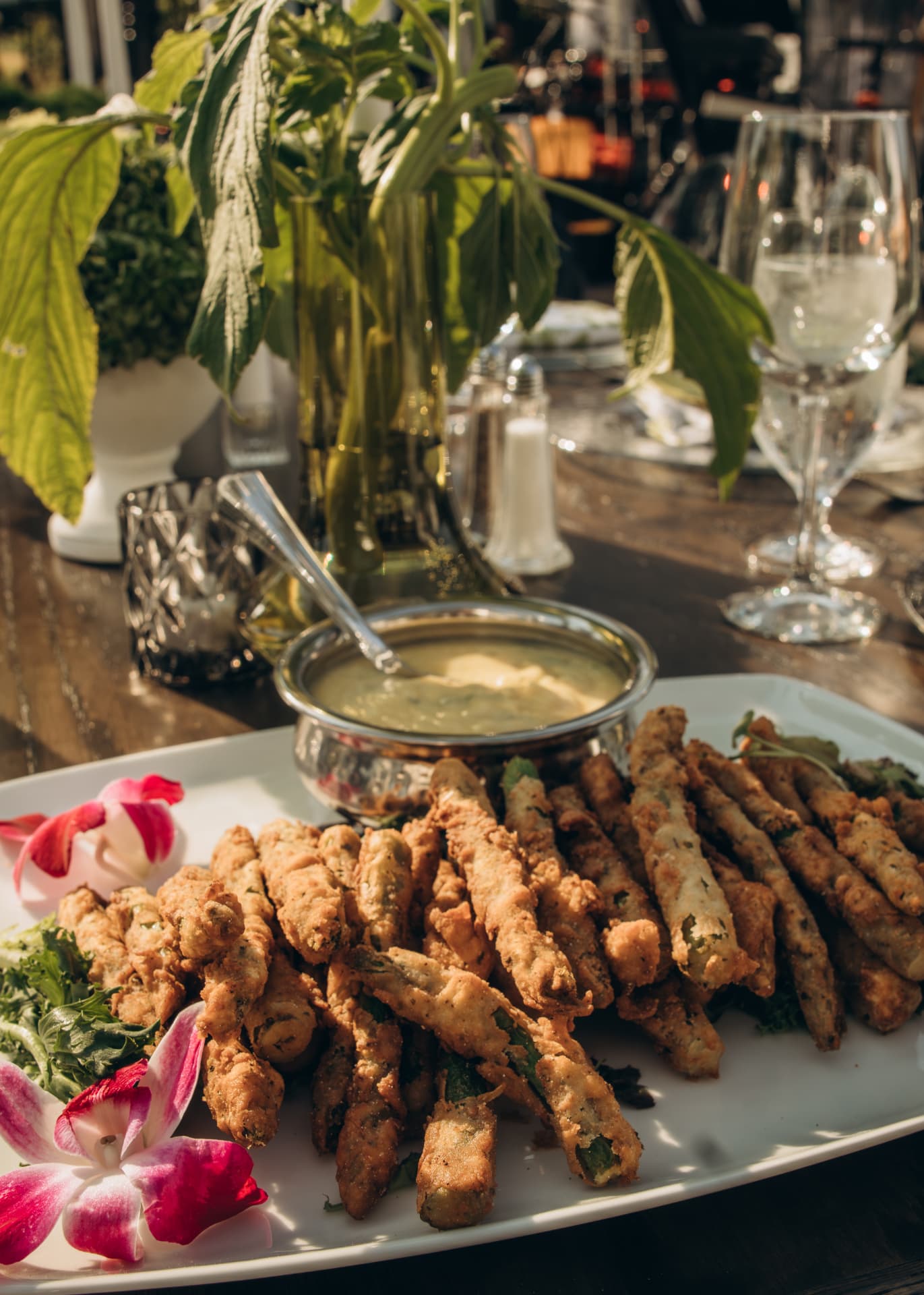 Crispy fried green beans with dipping sauce on a passed platter