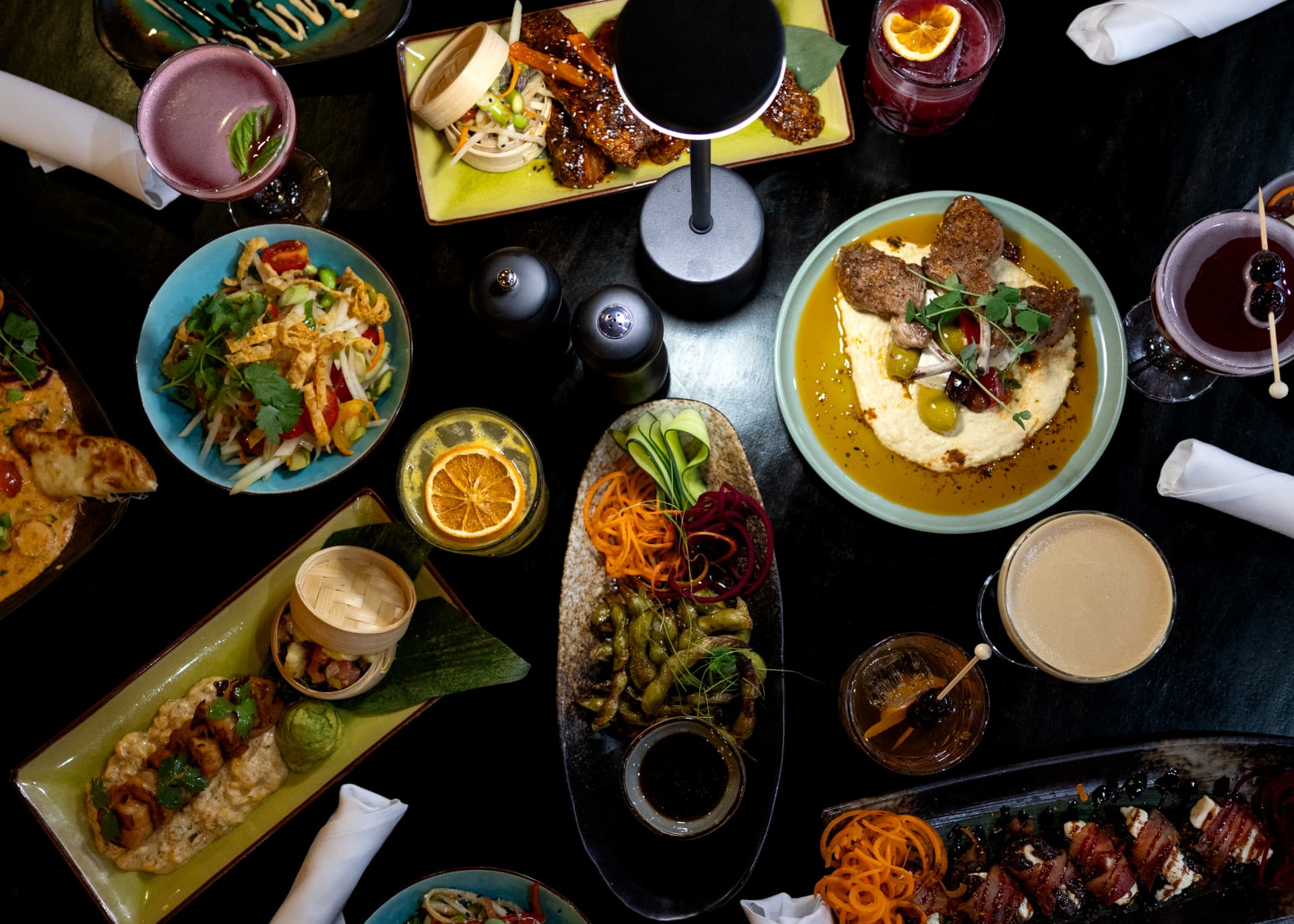 Overhead spread of Sequoia tapas and cocktails on a dark table