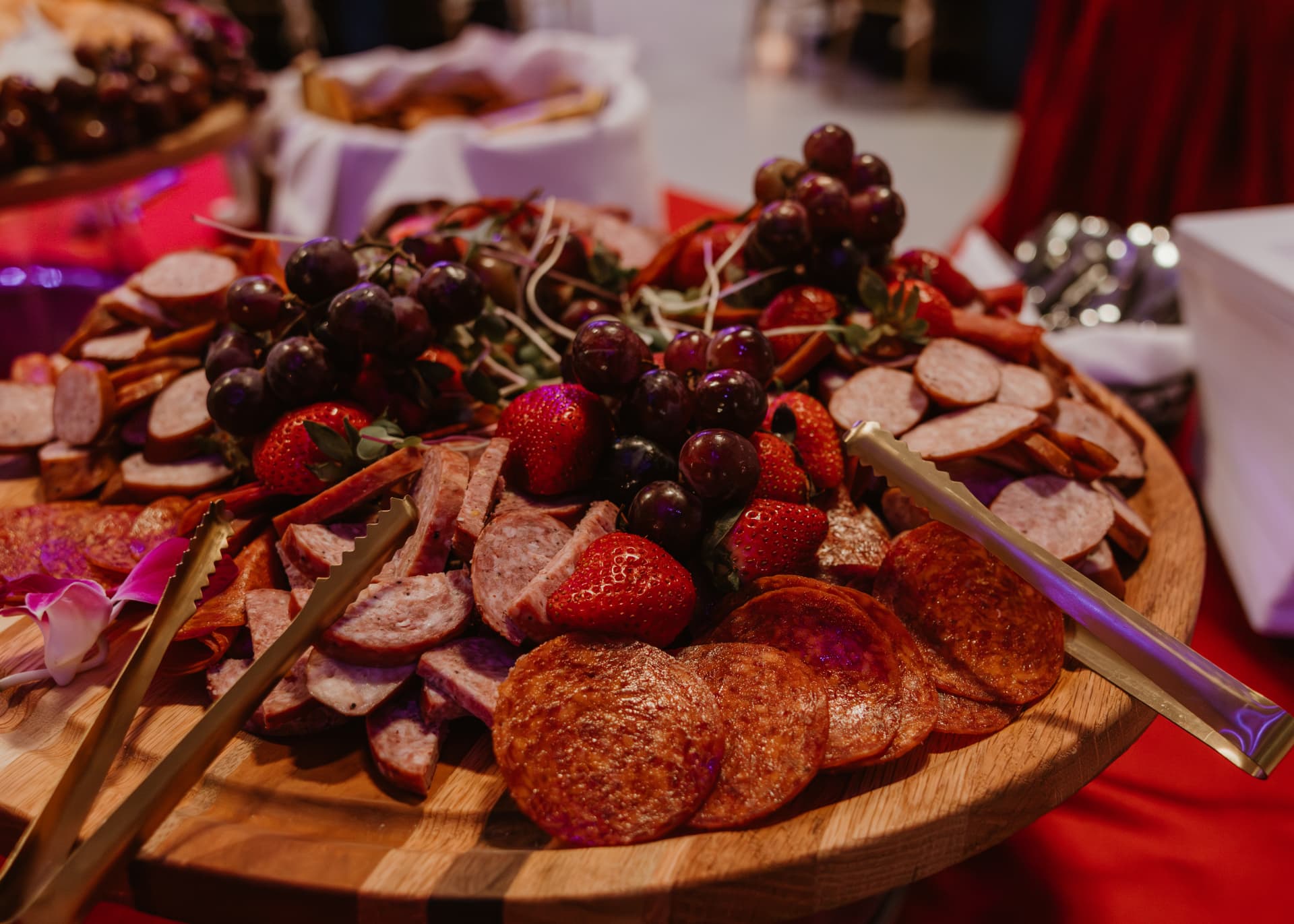 Charcuterie board with sausages, salami, grapes and strawberries